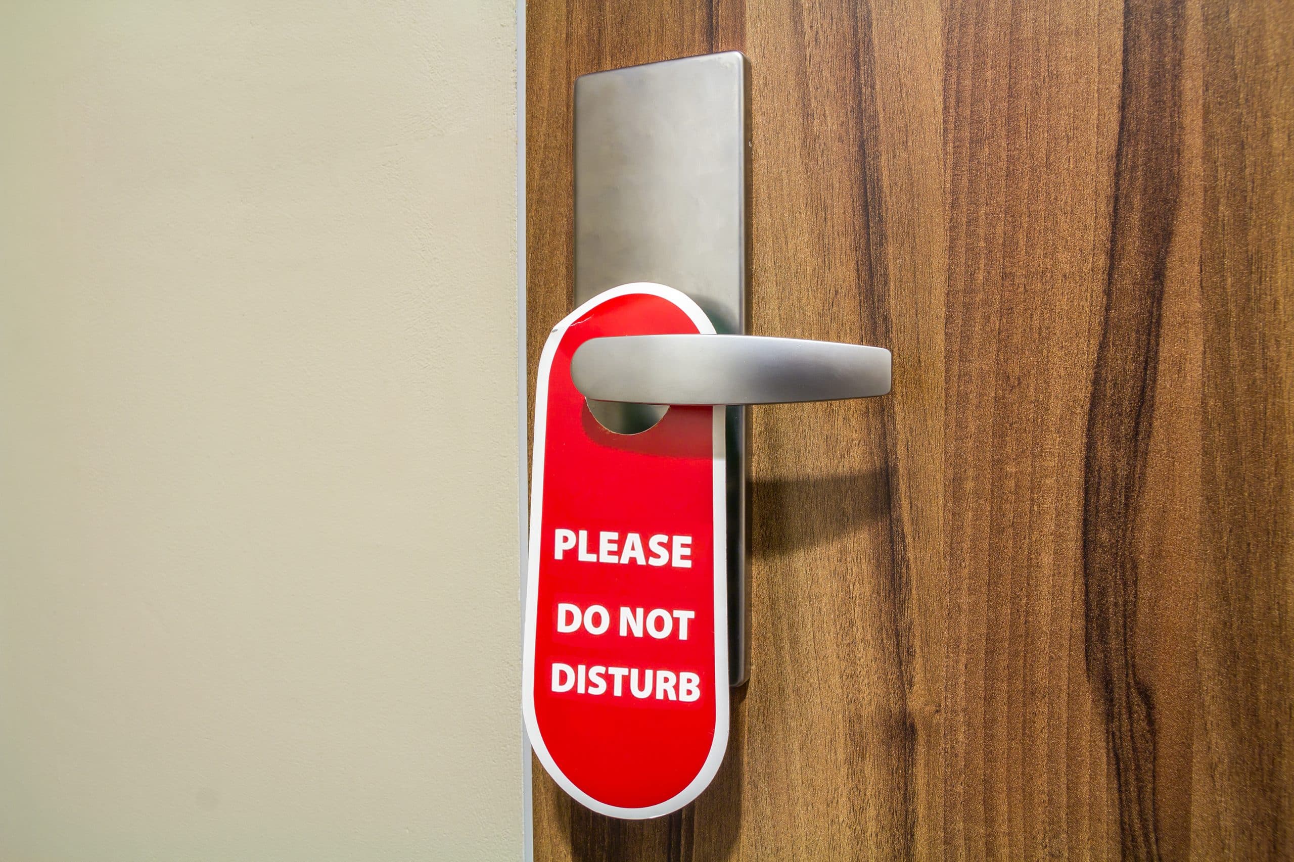 Door of hotel room with sign please do not disturb