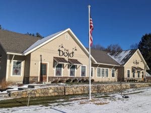 Wide view of the new Bradku Inc. commercial property featuring black cut aluminum dimensional signs for The Dojo and Glow spa, installed by Northshore Custom Signs